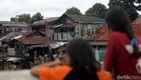 Dua orang warga melihat aliran Sungai Ciliwung yang tengah meluap.