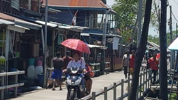 Warga Agats, ibu kota Kabupaten Asmat memakai motor listrik