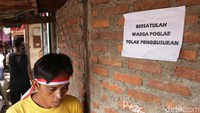 Aksi penolakan juga dilakukan warga dengan mengenakan ikat kepala berwarna merah putih.