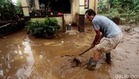 Seorang warga tengah membersihkan lumpur sisa banjir di kawasan Kampung Arus, Cawang, Jakarta Timur, Kamis (8/2/2018).