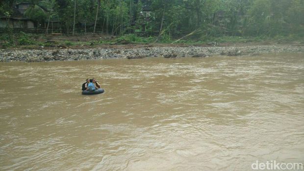 Anak-anak sekolah menyeberangi Sungai Oya pakai ban. 