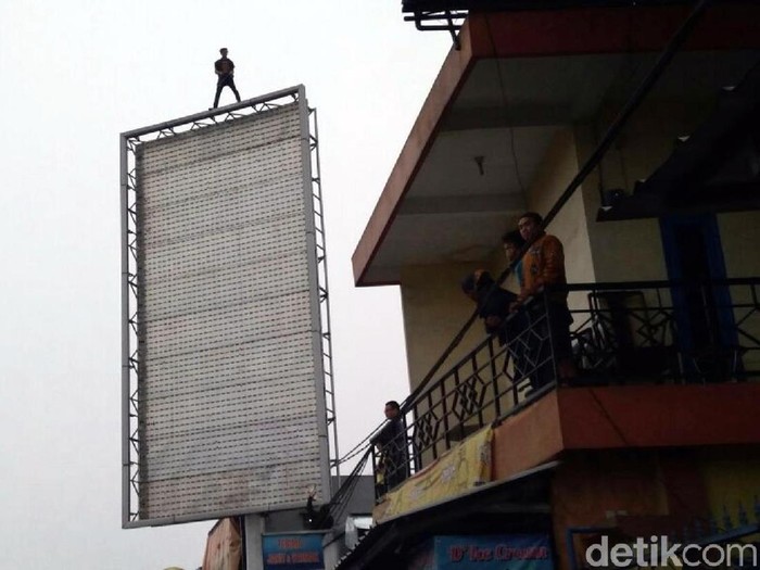 Bikin Panik, 3 Jam Lebih Pria Ini Berdiri di Atas Billboard