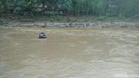 Potret anak-anak sekolah menyeberangi sungai yang alirannya cukup deras.