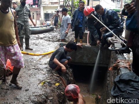 Warga, petugas Damkar dan Satpol PP bersih-bersih permukiman dari lumpur di Kampung Arus, Cawang, Jaktim, Kamis (8/2/2018)