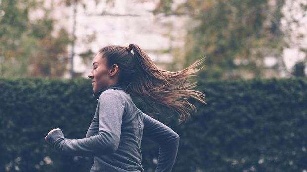 Woman running. Female runner jogging, training for marathon. Fit girl fitness athlete model exercising outdoor.