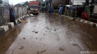 Lumpur yang terbawa arus banjir juga menyisakan jalanan yang kotor dan licin.