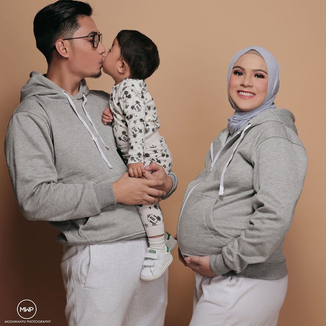 Nycta Gina belum lama ini melakukan maternity shoot. Ia mengambil tema yang lebih fun dan sporty. Nycta Gina dan suaminya Kinos memakai jaket yang sama, dan berfoto bersama anak pertamanya. Foto: Instagram