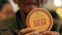 Seorang penerima bingkisan menunjukan kupon bingkisan Imlek.