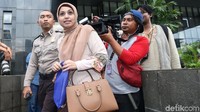 Nadia keluar gedung KPK dengan dikawal seorang polisi.