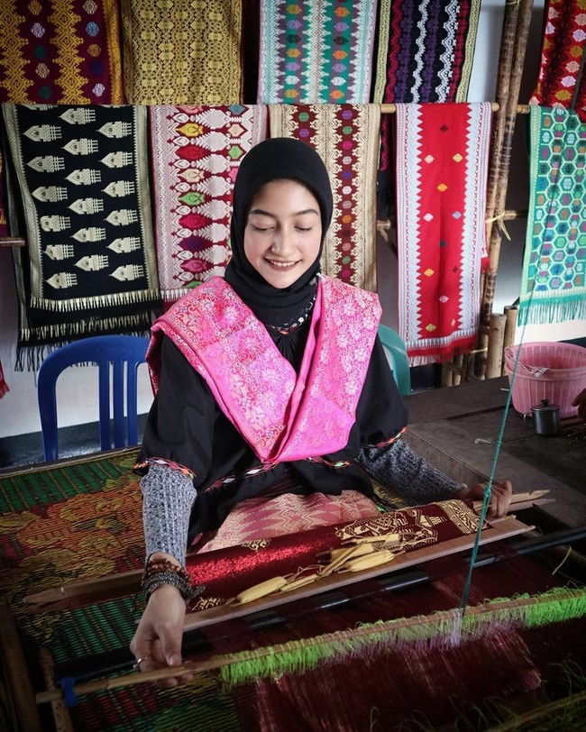 Dhika juga pernah mengunjungi Desa Sukakara, tepatnya Kampung Tenun Asli Lombok. Ia memakai baju lambung dan kain tentung songket. Di sini ia mengeksplor keindahan kain tenun dan rumah adat suku Sasak. Foto: Instagram