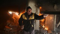 Seorang pria berada di dalam bangunan yang terbakar usai gempuran udara rezim Suriah di Ghouta Timur. Foto: REUTERS/ Bassam Khabieh