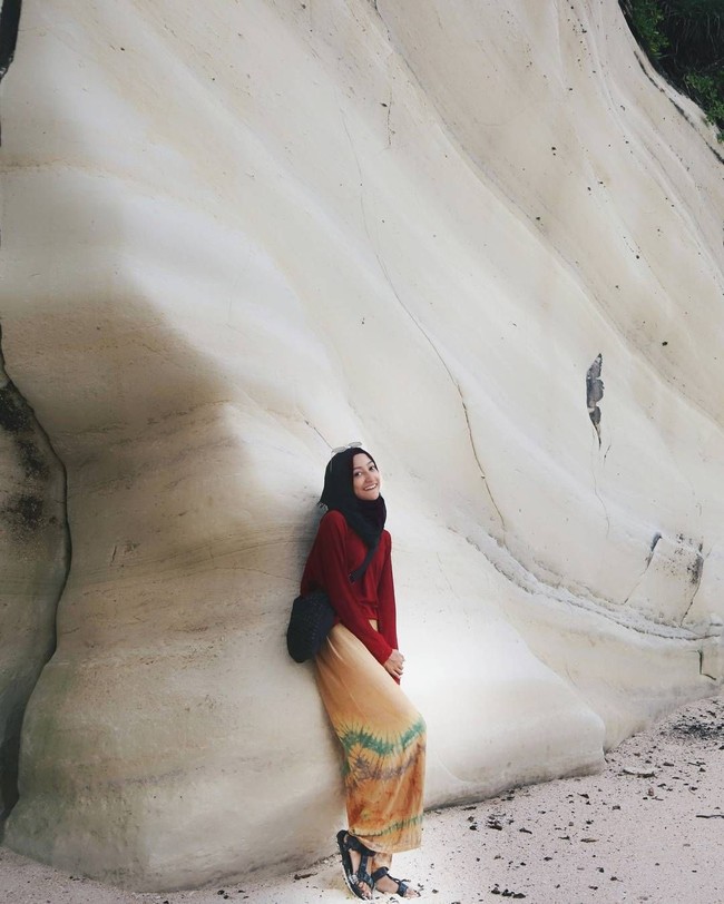 Mengunjungi Sumba Barat, Dhika tidak melewatkan Pantai Watu Bela. Menikmati pasir putih dan desiran ombak, ia tampak stylish dengan atasan berwarna merah dan celana tie dye yang longgar berwarna oranye. Foto: Instagram