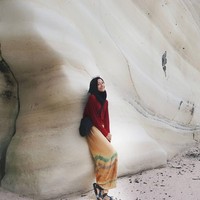 Mengunjungi Sumba Barat, Dhika tidak melewatkan Pantai Watu Bela. Menikmati pasir putih dan desiran ombak, ia tampak stylish dengan atasan berwarna merah dan celana tie dye yang longgar berwarna oranye. Foto: Instagram