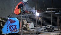 Seorang pekerja melakukan pengelasan untuk pembangunan terowongan.