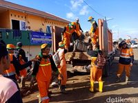 Petugas berjibaku bersihkan sampah sisa banjir di Kampung Pulo Description