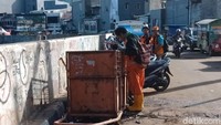 Foto: Mereka berbagi tugas. Sebagian personel Pasukan Oranye membersihkan sampah di pinggir jalan dan sebagian lagi membersihkan sungai.Fotografer: Eva/detikcom