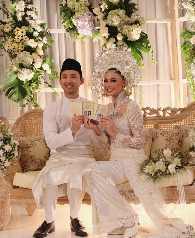 Untuk prosesi akad nikah, kedua sejoli ini kompak dalam balutan busana serba putih. Whulandary anggun dengan kebaya khas Minang, sementara sang suami gagah berbalut kemeja model jas tutup legkap dengan songketnya. Foto: Instagram