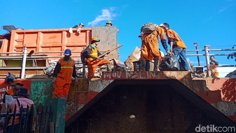 Petugas Angkut 5 Ton Sampah Sisa Banjir di Kampung Pulo Petugas Angkut 5 Ton Sampah Sisa Banjir di Kampung Pulo