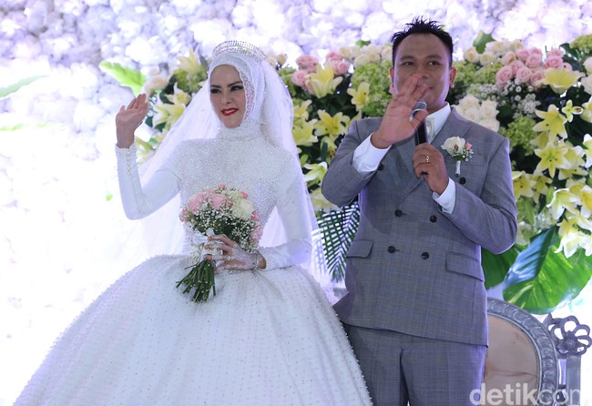 Acara dilanjutkan dengan resepsi di siang hari. Angel Lelga tampil bak puteri dalam dongeng dengan busana megah berwarna putih ditambah dengan tiara di kepalanya. Busananya ini merupakan karya Ivory Bridal. Foto: Palevi/detikHOT