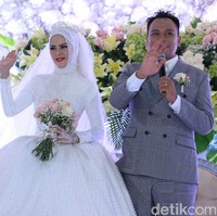 Acara dilanjutkan dengan resepsi di siang hari. Angel Lelga tampil bak puteri dalam dongeng dengan busana megah berwarna putih ditambah dengan tiara di kepalanya. Busananya ini merupakan karya Ivory Bridal. Foto: Palevi/detikHOT