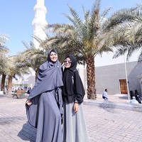 Ia pun kembali memakai busana dari Medina Zein saat berada di Mekah. Kali ini ia memakai hijab syari dan gamis berwarna abu-abu. Foto: Instagram Kartika Putri