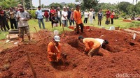 Petugas melakukan penggalian menggunakan cangkul. Sementara penggalian liang lahat untuk pemakaman massal menggunakan satu unit ekskavator.