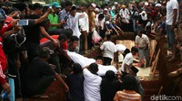 Jenazah dimasukkan ke liang lahat.