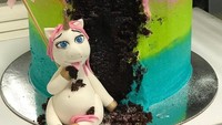 Kue warna hitam dengan lapisan krim pink,  hijau,  dan cyan ini temanya lebih unik. Si unicornnya terlihat masa bodo walau ketahuan sedang makan kue. Foto: Istimewa