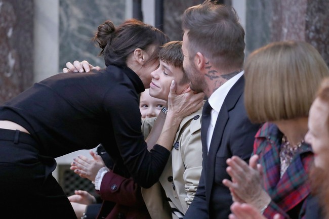 Sang Posh Spice juga mencium Romeo Beckham, putra keduanya yang terjun ke dunia modeling sebagai wajah Burberry. (Foto: JP Yim/Getty Images)