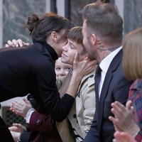 Sang Posh Spice juga mencium Romeo Beckham, putra keduanya yang terjun ke dunia modeling sebagai wajah Burberry. (Foto: JP Yim/Getty Images)