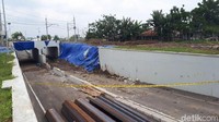 Lokasi gerbang yang roboh itu juga berdekatan dengan lokasi longsor pada Senin (5/2) lampau, yakni longsor yang mengakibatkan robohnya tembok beton dan menimpa mobil, mengakibatkan dua korban dan salah satunya meninggal dunia setelah dilarikan ke rumah sakit. Lokasi itu terlihat ditutupi terpal biru, tak jauh dari lokasi gerbang roboh yang sekarang. Kedua lokasi terletak berseberangan, hanya dibatasi ruas Jalan Perimeter Selatan. (Ahmad Bil Wahid/detikcom)