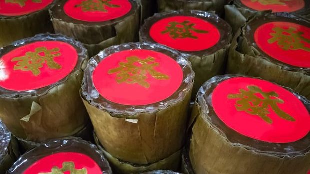 Nian Gao served at the table with a glass of orange juice cupcakes and red packets. image is suitable for food and beverage articles and all design related to the celebration of Chinese New Year