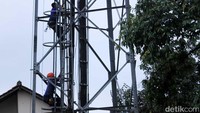 Petugas Damkar memanjat tower untuk mengevakuasi Riswan.