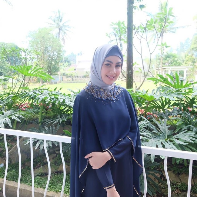 Saat idul fitri, Kartika Putri pun tampil cantik memakai hijab segiempat berwarna abu-abu. Ia memadukan hijabnya dengan dress berwarna biru dongker dengan sentuhan payet di bagian leher. Foto: Instagram