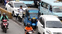 Seorang pelajar melintas di antara kendaraan yang terjebat kemacetan di Jatinegara.