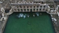 Tampak beberapa orang tengah asyik berenang di kolam yang dari jauh berwarna hijau itu. (Foto: Dok. Anadolu Agency)