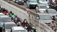 Seorang pelajar mengendarai sepeda motor tanpa memakai helm di Jalan Raya Jatinegara, Jakarta Timur.