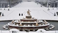 Taman Istana Versailles pun berubah jadi seperti latar dalam film animasi Disney berjudul Frozen. Hanya ada warna putih di mana-mana (Cristophe Simon/AFP)