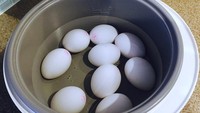 Masukkan telur ke dalam rice cooker yang telah berisi air mendidih, kemudian rebus selama 5 menit. Angkat telur, rendam air dingin lalu tiriskan dan kupas.Foto: Istimewa