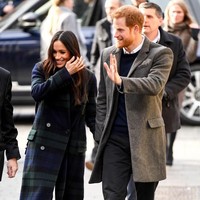 Di kunjungan tersebut, Meghan Markle tampil stylish dalam balutan mantel kancing ganda bermotif tartan dari rumah mode Inggris Burberry. Foto: Getty Images