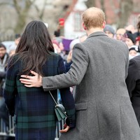 Pangeran Harry menunjukkan sisi protektifnya dengan merangkul Meghan Markle dari belakang. Foto: Getty Images