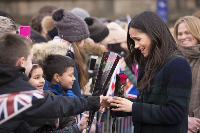 So sweet! Meghan Markle mendapatkan bunga mawar dari anak kecil di barisan massa yang menunggunya. Foto: Getty Images