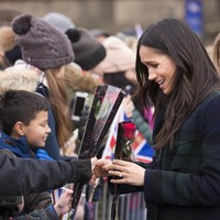 So sweet! Meghan Markle mendapatkan bunga mawar dari anak kecil di barisan massa yang menunggunya. Foto: Getty Images