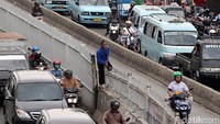 Meski beresiko tinggi dan sangat berbahaya, pejalan kaki tetap nekat naik pagar pembatas.
