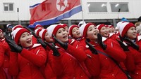 Mereka mengibarkan bendera Korut sambil meneriakkan yel-yel yang berarti semangat tim atau negara kami bersatu (Foto: Reuters)