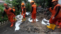 Petugas tengah memasukkan batu ke dalam bronjong kawat tersebut.