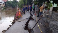 Pembaca detikcom, Sinyo Stevanus mengirimkan foto kondisi Jalan Kesatrian X RT 12/03 yang terbelah. Petugas pasukan oranye dan pasukan biru tampak tengah bertugas