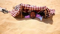 Rasanya dijamin panas membara! Terang saja, khasiat pasir gurun ini baru akan terasa jika matahari tepat berada di atas kepala. (Asmaa Waguih/Reuters)