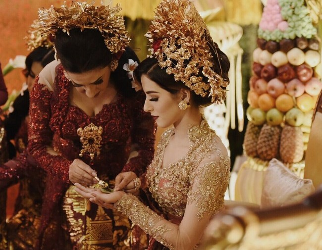 Menjalani salah satu adat Arab yaitu acara Pacar, Tasya Farasya berganti kostum memakai adat Bali. Di acara itu, Tasya dipakaikan henna di telapak tangan oleh ibunya. Foto: Instagram