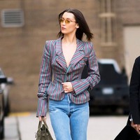 Blazer tanpa menggunakan busana di dalamnya, celana jeans, boots, dan kacamata matrix, memberikan sentuhan vintage ala 90-an di penampilan Bella Hadid.Foto: Getty Images